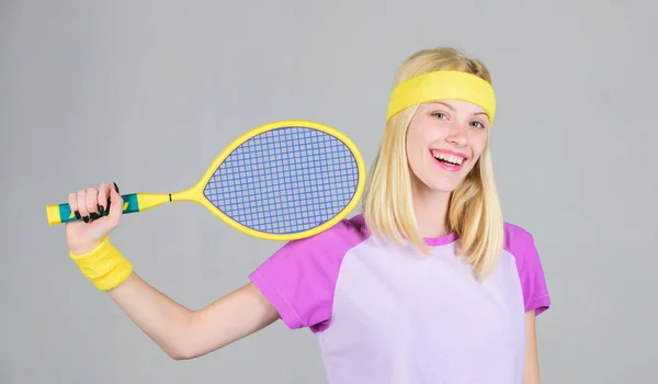 Sportler halten Tennisschläger in der Hand auf grauem Hintergrund. Tennissport und Unterhaltung. Tennisclubkonzept. Mädchen entzückende Blondine spielen Tennis. Sport zur Erhaltung der Gesundheit. Aktive Freizeit und Hobby — Stockfoto