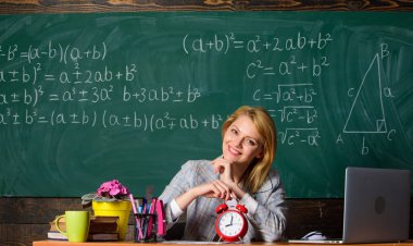 Acele etme. öğretmen ile çalar saat, yazı tahtası. Zaman. Çalışma ve eğitim. Modern okul. Bilgi gün. Okul. Evde eğitim. mutlu bir kadın. Okula dönüş. Öğretmenler günü. kadın sınıfta
