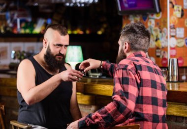 Barda dinlenen adamlar. Sert alkol içecekler. Cuma günü barda rahatla. Barda dinlenen arkadaşlar. Sarhoş sohbeti. Şerefe kavramı. Hipster, bar tezgahında arkadaşıyla içki içen vahşi sakallı adam.