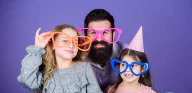 A get together. Family party. Happy family celebrating birthday party. Family of father and daughters wearing party goggles. Father and girl children enjoying party time. Having a family celebration