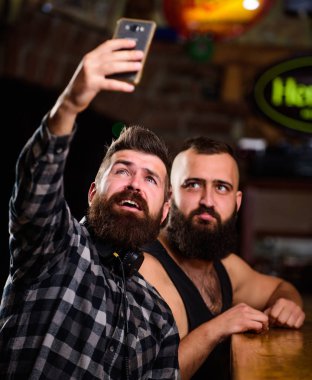 Çevrimiçi iletişim. Adam hipster tutun smartphone sakallı. Alarak selfie kavramı. Selfie arkadaşlar sosyal ağlara göndermek. Adam bar bira içiyor. Harika akşam barda hatırlamak selfie fotoğraf çekmek