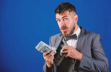 İşadamı nakit para var. Zenginlik ve refah kavramı. Nakit kolay ve hızlı bir şekilde olsun. Nakit işlem iş. Resmi takım elbise mavi arka plan doları banknot yığını tutun. Kolay nakit krediler