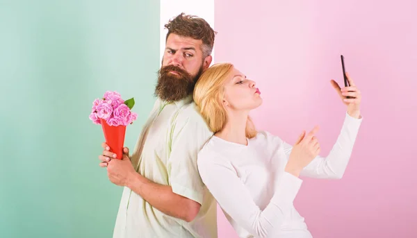 Sharing happy selfie. Woman capturing happy moment boyfriend bring bouquet flowers. Couple in love bouquet dating celebrate anniversary relations. Capturing moment to memorize. Taking selfie photo