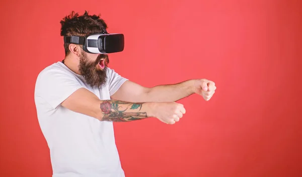 Conceito de corrida virtual. Homem com barba em óculos VR carro de condução, fundo vermelho. Guy jogar jogo de corrida em VR. Hipster na cara excitada dirigindo carro em alta velocidade na realidade virtual — Fotografia de Stock