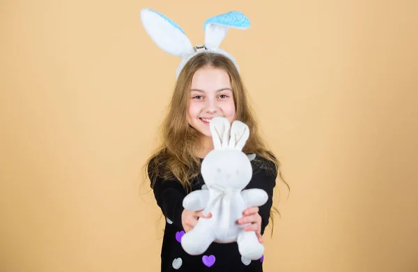Надежда и невинность. Счастливый ребенок улыбается в стиле пасхального кролика. Пасхальный кролик приносит подарки хорошему ребенку. Девочка с мягкой кроличьей куклой на Пасху. Маленький ребенок с милой кроличьей игрушкой — стоковое фото