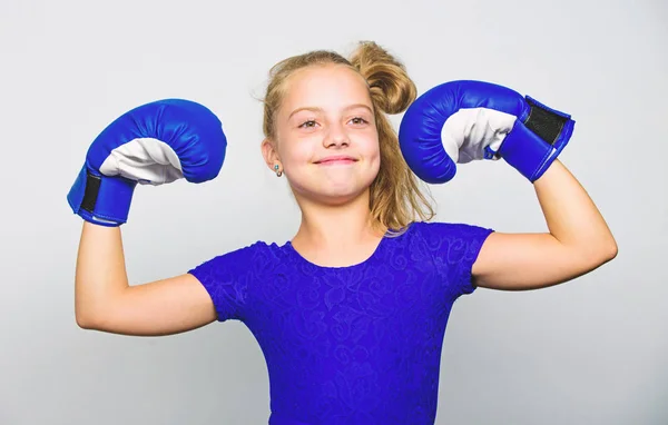 Flicka barn lyckliga vinnaren med boxningshandskar poserar på grå bakgrund. Hon känner sig som vinnare. Uppfostran för ledarskap och vinnare. Feministiska rörelsen. Starka barn stolt vinnare boxning konkurrens — Stockfoto