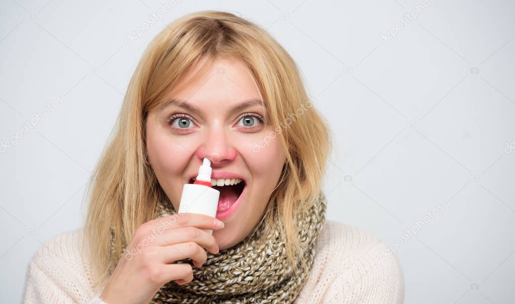 Success in clearing up. Treating common cold or allergic rhinitis. Sick woman spraying medication into nose. Cute woman nursing nasal cold or allergy. Unhealthy girl with runny nose using nasal spray