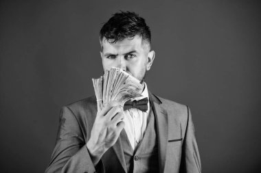 Resmi takım elbise mavi arka plan doları banknot yığını tutun. İşadamı nakit para var. Zenginlik ve refah kavramı. Nakit para kolay ve hızlı bir şekilde almak. Para gibi kokuyor. Kolay nakit krediler
