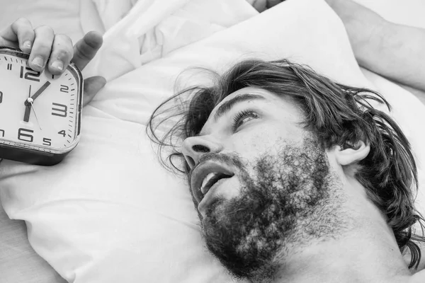 Hombre guapo usando el reloj en la cama después de despertarse por la mañana. Hombre perezoso feliz despertando en la cama levantando las manos por la mañana con sensación fresca relajado. Un hombre joven y guapo se despierta completamente descansado. . —  Fotos de Stock