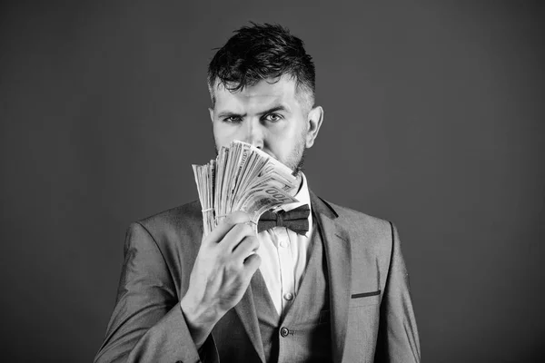 Man formal suit hold pile of dollar banknotes blue background. Businessman got cash money. Richness and wellbeing concept. Get cash money easy and quickly. Smell of money. Easy cash loans