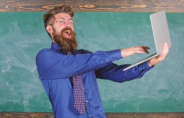 Examen réussi. Passer le test en ligne. Professeur barbu homme heureux avec ordinateur portable moderne passé test en ligne fond tableau. Lunettes de vue professeur Hipster tenir ordinateur portable passé contrôle des connaissances à distance — Photo