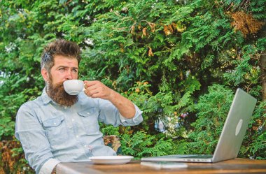 Hayattan zevk için zaman ayırın. Adam kahve rahatlatıcı Teras dalları arka plan içer. Aroma kapuçino. Hoş bir an. Sakallı adam hipster yapmak için kahve içmek duraklatma ve dizüstü bilgisayar ile oturup süre sakin ol