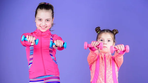 Сильный и здоровый. Милые сестры имеют физическую подготовку мышечной силы. Маленькие девочки укрепляют свои руки. Маленькие дети развивают силу с гантелями. Подходят дети, тренирующие свою силу — стоковое фото