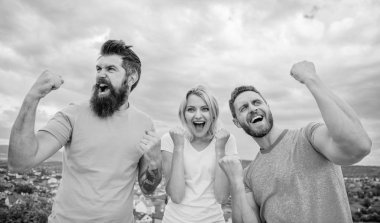 Favori takım yarışmasını kazandı. Kazanan takım davranışlarını. Kadın ve erkek göz başarılı zafer gökyüzü arka plan kutlamak. Üçlü stand yükseltilmiş yumrukları ile mutlu. Biz kazananlar vardır. Başarı kutlamak