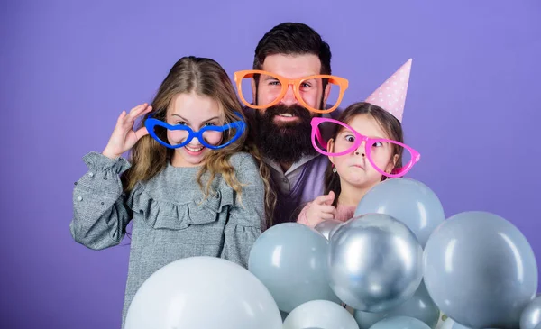 Getting funny. Family of father and daughters wearing party goggles. Father and girl children enjoying party time. Happy family celebrating birthday party. Family party. Having a family celebration