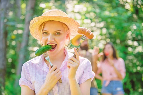 Meisje glimlachend gezicht houdt vorken met worst en komkommer. Vegetarische levensstijl is haar keuze. Alternatieve voeding voor vegetariërs. Vegetariërs voeding keuze. Keuze tussen vlees of groenten — Stockfoto