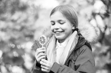 Tatlı onu kupa Cadılar Bayramı günü şeker. Şeker ya da tatlı şeker. Çocuk kız giyim ceket sonbahar sezonu için. Neşeli çocuk yemek lolipop şeker sonbahar güneşli günü. Kız güler yüz sopa üzerinde şeker tutun