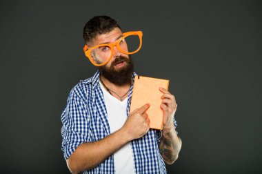 Onun el kitabı için dikkat çekmek. Kitap nerd süslü gözlük takıyorum. Adam ders kitabı ile parti bardaklarda sakallı. Çalışma kitabına parmakla inek. Üniversite erkek öğrenci ders notları ile