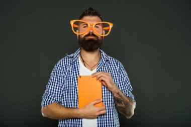 Çizgi roman ve mizah duygusu. Dersler yetişkin eğitimi. Kendi eğitim kavramı. Edebiyat kulübü. Hobi olarak kitap okumak. Eğlenceli bir çalışmadır. Hipster sakallı adam komik gözlük Not Defteri veya kitap tutun. Bu kitabı okuyun