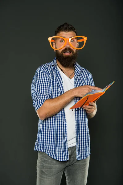 Freak und Freek. bärtiger Mann mit Parteibrille und Lesebuch. Studium Nerd hält Lektion Buch. männlicher Student mit Vorlesungsnotizen. Buch-Nerd mit schicker Brille — Stockfoto