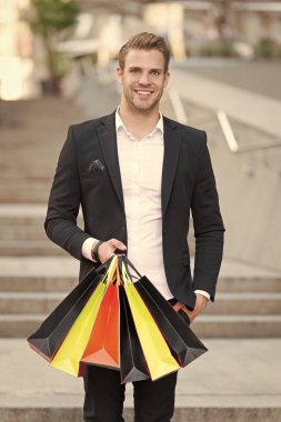 Seçkin alışveriş. Adam alışveriş alışveriş torbaları kentsel arka plan taşır. Başarılı bir iş adamı sadece lüks özel markalar ve yüksek moda butiklerinde alışveriş tercih. Butik Galeri istemci