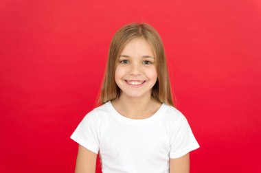 Samimi duygular. Parlak bir gülümseme kavramı. Kız yüz kırmızı arka plan üzerinde gülümseyen mutlu. Duygusal çocuk neşeli güler yüz. Neşeli sevimli kız gülümsüyor. Olumlu ve iyimser. Neşeli ruh