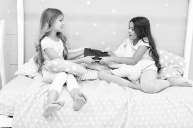 Kardeşler arası rekabet konsepti. Kardeşler arası ilişki sorunları. Kitabı arkadaşınla paylaş. Yatak odasındaki çocuklar akşam masalları okumak istiyorlar. Bu benim kitabım. Kız rekabeti. Kitabını paylaşmak istemiyor.