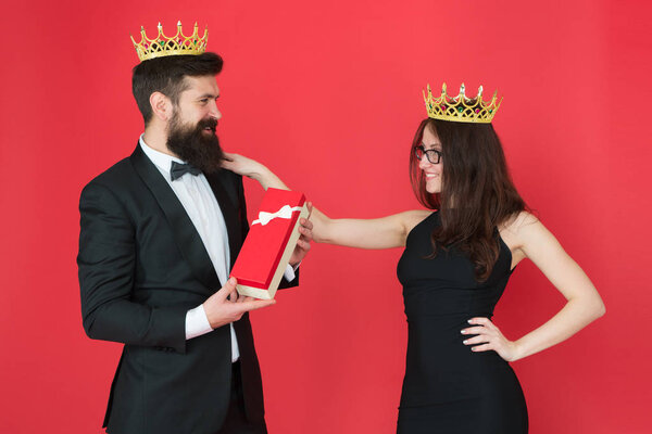 Royal family. Couple in love royal family. Elite society. King and queen formal event. Royal gift. Queen of his heart. Man bearded king in tuxedo golden crown giving gift box to woman elegant dress