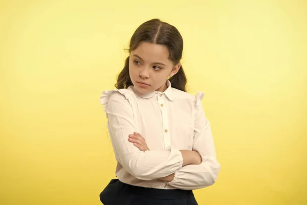 That is not fair. Pupil not agree with mark. Girl serious face offended yellow background. Kid unhappy looks strictly. Girl folded arms on chest looks serious. Pupil disagree with school rules — Stock Photo, Image
