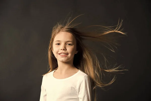 Φυσική ομορφιά. Κορίτσι παιδί μακριά μαλλιά που φέρουν στον αέρα, μαύρο φόντο. Παιδί με φυσικό όμορφα υγιή μαλλιά. Γρήγορες συμβουλές για υγιή μαλλιά. Μεγαλώνει τα μαλλιά σύσταση. Εξαιρετικά αποτελεσματικό προϊόν — Φωτογραφία Αρχείου