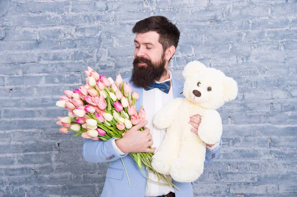Thank you. Spring gift. Bearded man hipster with spring flowers. Bearded man with tulip bouquet and bear. Womens day. March 8. Love date. international spring holiday. spring holiday celebration — Stock Photo, Image