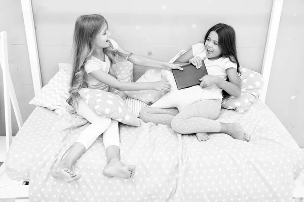 Problemas de relaciones entre hermanas. Compartir libro con un amigo. Los niños en el dormitorio quieren leer cuento de hadas por la noche. Este es mi libro. Rivalidad femenina. Ella no quiere compartir su libro. Concepto de rivalidad entre hermanas — Foto de Stock