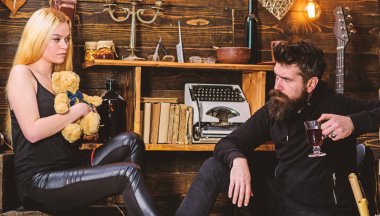 Çift gamekeepers evde, ahşap iç arka plan romantik akşamın. İki aşık oyuncak ayı ve mulled şarap. Kız ve erkek rahat yüzleri sıcak atmosferinin keyfini çıkarın. Rahatlatıcı kavramı