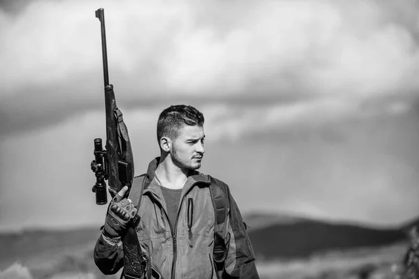 Hombre brutal chico guardabosques naturaleza antecedentes. Regulación de la caza. Pistola de fusil Hunter en la cima de la montaña. Guy cazador barbudo pasar el tiempo libre de caza en los pájaros. Caza concepto de pasatiempo masculino —  Fotos de Stock