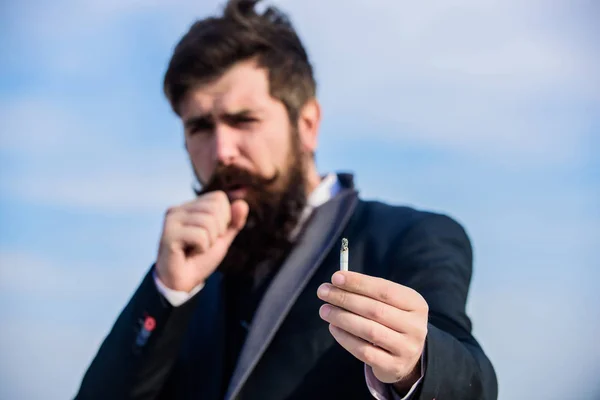 Bearded hipster smoking cigarette sky background. Guy cigarette enjoy nicotine influence. Man with beard mustache hold cigarette. Cigarettes help us with everything from boredom to anger management