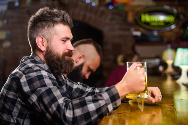 Homem com barba passar o lazer no bar escuro. Homem barbudo hipster brutal senta-se no balcão do bar a beber cerveja. Peça bebida alcoólica. O bar é um lugar relaxante, tome uma bebida e relaxe. Hipster relaxante no bar com cerveja — Fotografia de Stock