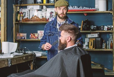 Damat kavramı. Sakal hipster istemcisinin damat ile meşgul berber, güzellik arka plan sağlar. Şık berber dükkanı olarak profesyonel kuaför tarafından hizmet veren cape hipster sakal ile kaplı