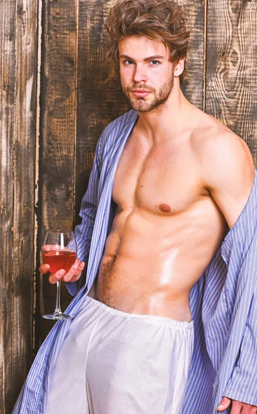 Chico atractivo relajándose con bebida alcohólica. Hombre sexy pecho piel sudorosa celebrar wineglass. Bebe vino y relájate. El soltero disfruta del vino. Macho tousled cabello degustar vino de lujo. Concepto erótico y deseo — Foto de Stock