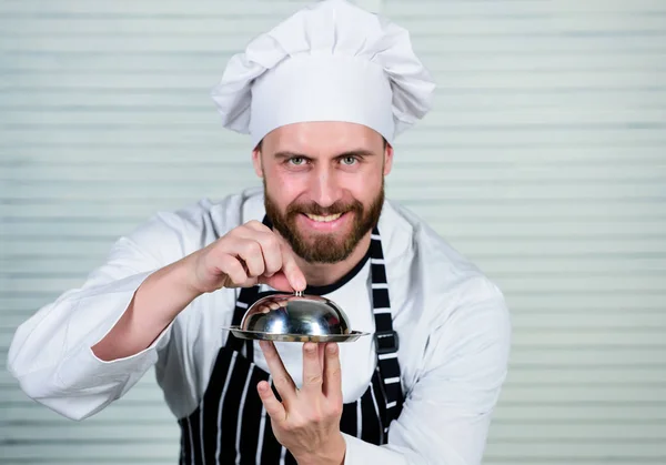 Haute cozinha não é snooty. Chef cozinhar em uniforme de pé com prato delicioso. Bonito homem de avental e chapéu de cozinha. Mestre chef servindo refeição no restaurante. Ter cozinhado comida é mais fácil de digerir — Fotografia de Stock