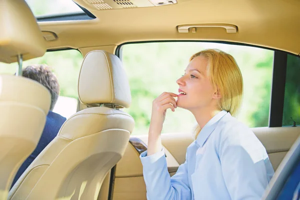 Business woman sit on backseat. Busy lady passenger leather car salon enjoy journey with chauffeur. Business lady passenger luxury car salon. Personal assistant and driver. Business life concept