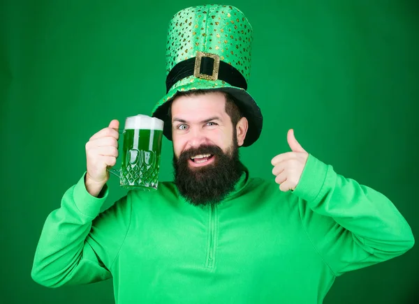 Hip hip hooray its st pattys day. Leprechaun hipster holding beer mug. Bearded man toasting to saint patrick. Irish man with beard giving thumbs up to green beer. Celebrating saint patricks day — Stock Photo, Image