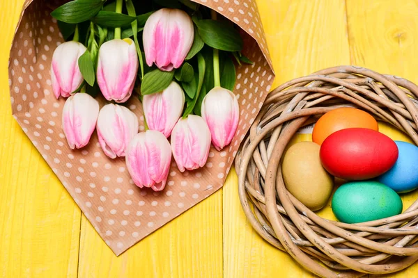 Gelenek Paskalya kutlamak. Mutlu Paskalya sezon. Paskalya geliyor. Paskalya yumurtası toplama. Bahar vibes. Renkli yumurta ve buket taze Lale çiçek sarı tablo arka plan üzerinde. Bahar tatil — Stok fotoğraf