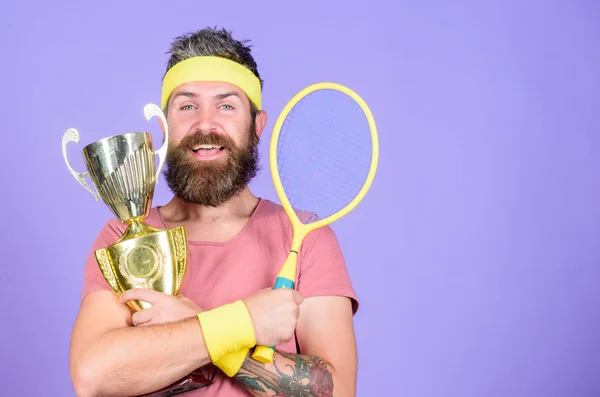 Win every tennis match i take part in. Tennis player win championship. Athlete hold tennis racket and golden goblet. Man bearded hipster wear sport outfit. Success and achievement. Win tennis game