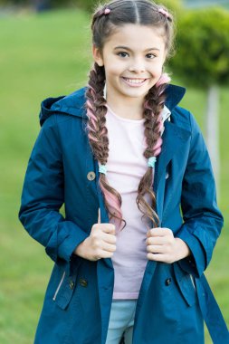 Küçük kız için bahar modası. Parkta son moda saç stili olan küçük bir kız. Sonbahar modası. Parkta şık saçları olan mutlu bir çocuk. Doğa manzarası. Parklar ve açık hava. Çok güzel.