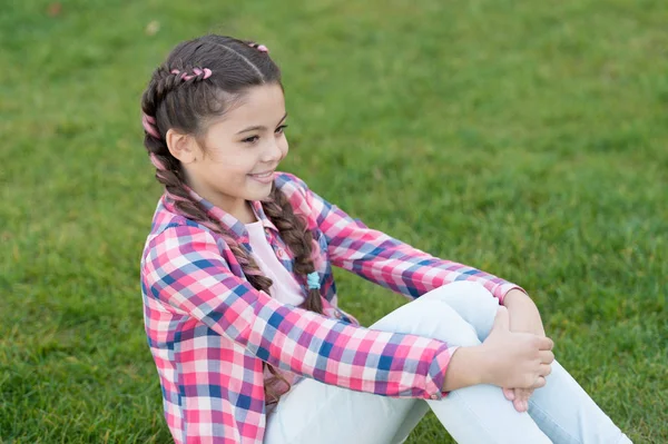 Un picnic perfecto. el mejor fin de semana. niña pequeña relajarse en la hierba verde. Parques y exteriores. Naturaleza de primavera. Picnic de verano. Niña de la escuela pequeña con el pelo de moda. Feliz infancia. Parque de picnic con la familia — Foto de Stock