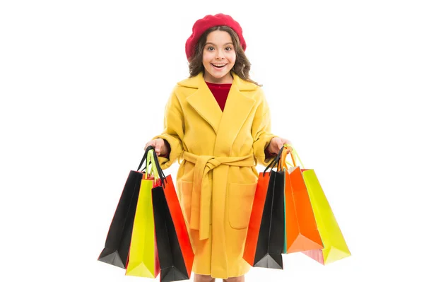 Mädchen halten Einkaufstüten in der Hand. Modell mit langen Haaren auf weißem Hintergrund. Kinder tragen Geschenke in Papiertüten. kleiner Shopaholic mit Einkaufstüten. Modetrend und Vertriebskonzept. Online einkaufen — Stockfoto