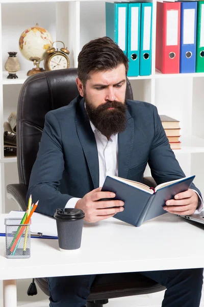 Libro de negocios de autoridad de lectura. Hombre barbudo hipster jefe sentarse sillón oficina interior leer libro. Jefe en el trabajo. Guy ropa formal estilo corporativo de trabajo. Literatura empresarial. Jefe leyó el libro — Foto de Stock