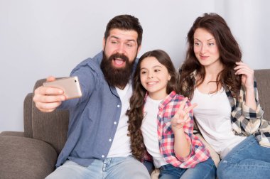 Smartphone için selfie kullanın. Dostu aile birlikte eğleniyor. Anne baba ve kızı kanepede rahatlatıcı. Aile fotoğrafı için poz. Mutlu anları yakalayın. Aile selfie. Aile birlikte hafta sonu geçirmek
