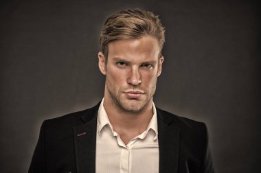 Olarak, onun görünümünü kendine güvenen bir adam. Güven ve erkeklik. Adam yakışıklı çekici formal giyim. Kıl ve saç modeli ile de bakımlı adam gri arka plan. Maço emin katı yüz yakın çekim