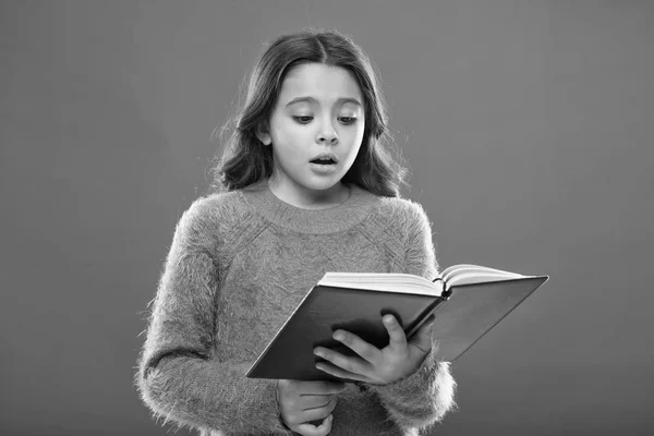 Pratique de lecture pour les enfants. Littérature pour enfants. Fille tenir livre lire l'histoire sur fond orange. L'enfant aime lire le livre. Concept de librairie. Magnifiques livres gratuits pour enfants disponibles à la lecture — Photo